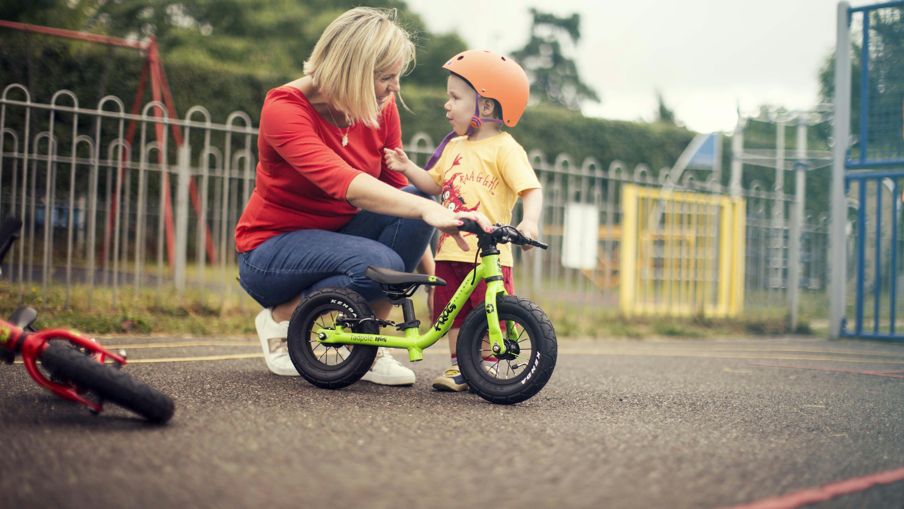child with a green balance bike 