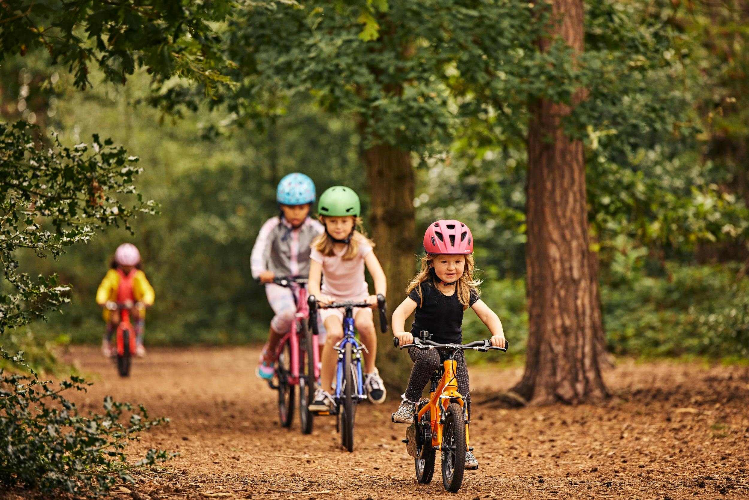 kids cycling on forest path